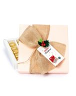 Boîte carrée rose de 20 chocolats, pince houx et noeud jute